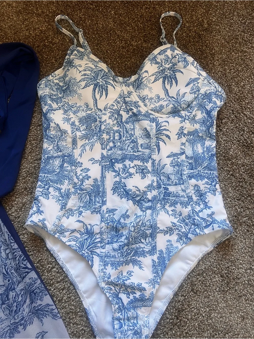 White and navy onepiece swimsuits with matching coverup.